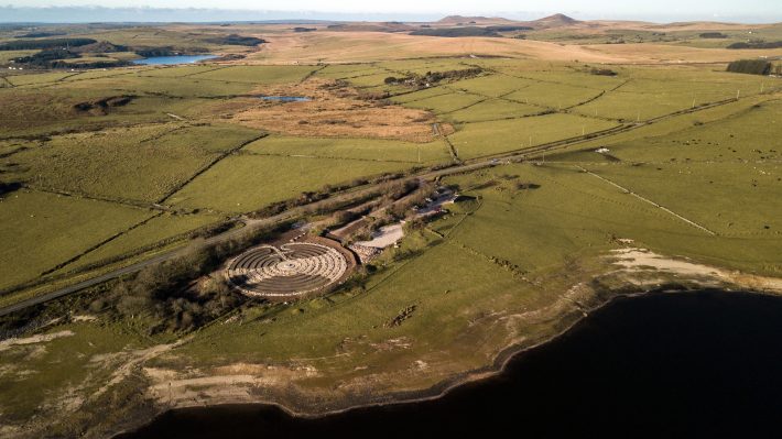 An aerial view of Bodmin Moor showing the Kerdroya Lanscape Labyrinth at the edge of Colliford Lake, the outline of Cornwall is represented in the Labyrinth with pale gravel outline